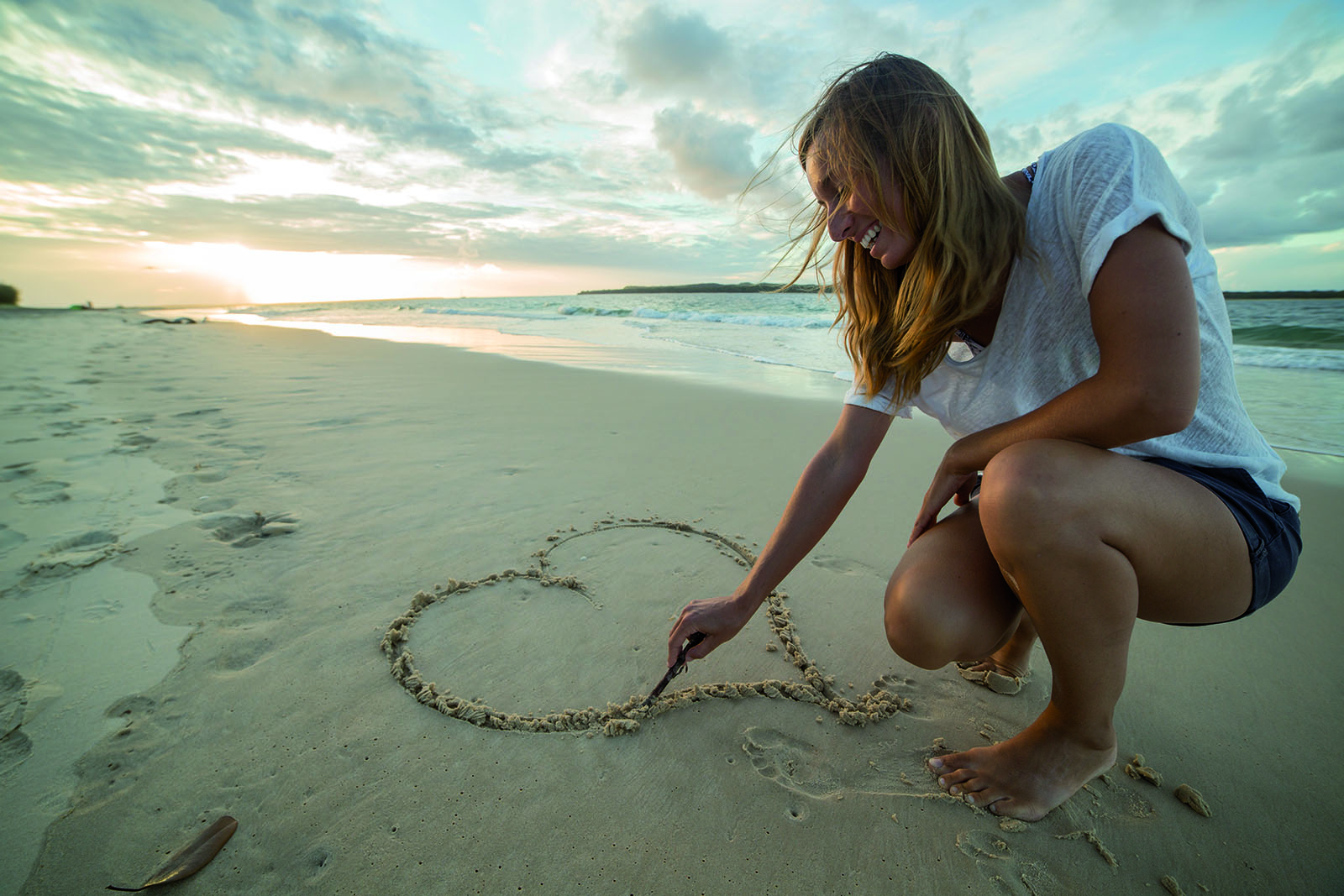 Beziehung im Fokus, Einzeltherapie, Dr. Marlies Potthoff München; Frau zeichnet alleine Herz in den Sand am Strand